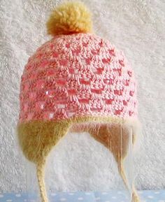 a crocheted hat is sitting on top of a clear glass cup with a yellow string