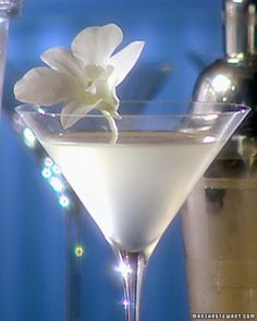 the martini is ready to be served with an orchid garnish on the rim