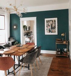 a dining room with green walls and wooden floors