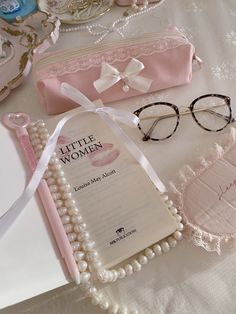 a pair of eyeglasses sitting on top of a table next to a book