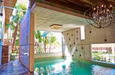 an indoor swimming pool with chandelier hanging from the ceiling and wooden flooring