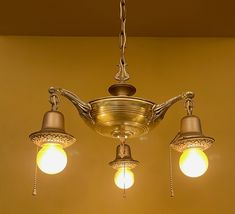 three light fixtures hanging from the ceiling in a room with yellow walls and flooring