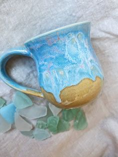 "A pretty mug for the days when you wish your toes were in the sand instead of slippers. ;) Made with white clay and glazed with a tan coat on the bottom and a series of blues and opal pink gloss over the top. Photo is color accurate! Handmade, wheel-thrown mug. The mug is approximately 4\" tall with a 3.25\" diameter. Holds approx. 10-12 oz. Please note your mug will be chosen from a batch of 5, so May differ slightly from the exact photo listing.  Everything is designed and handmade in Los Angeles, California. Check out my store for more and save by bundling purchases. I am always open to custom orders and with different colors. Feel free to reach out for more details! :) All purchases are protected or wrapped using reused or 100% recycled materials for maximum eco-friendliness.  Check o Pottery Photography, Pretty Mug, Beach Mug, Instagram Sales, Pink Gloss, Beach Pottery, Handmade Ceramics Pottery, Pottery Pot, Tan Coat