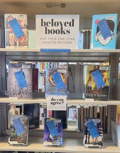 several books are displayed on shelves in a bookstore's bookcase, with one being blue and the other is black