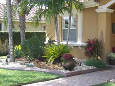 a house with landscaping and palm trees in the front yard