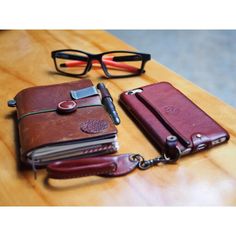 a pair of glasses sitting on top of a wooden table next to a leather wallet