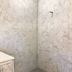 a bathroom with white marble walls and floor