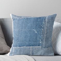 a blue denim pillow sitting on top of a couch