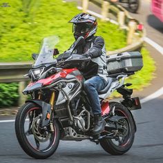 a man riding on the back of a motorcycle down a curvy road