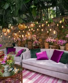 a living room filled with lots of furniture and flowers on the wall behind it is a stone wall