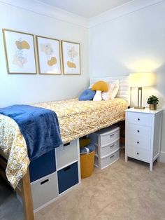 a bedroom with a bed, nightstands and two pictures on the wall above it