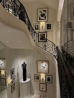 a staircase in a home with pictures on the wall and an iron banister next to it