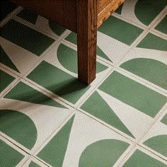 a green and white tiled floor next to a wooden table