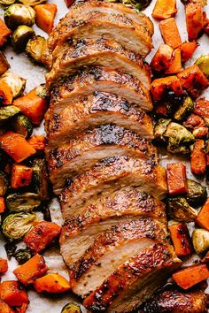 sliced pork and roasted vegetables on a baking sheet