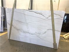 a white marble counter top sitting in a room next to some other pieces of wood