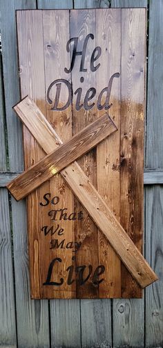 a wooden cross with the words he died on it