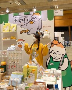 a woman standing in front of a table with cakes and other items on it at a store