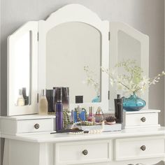 a white dresser topped with lots of cosmetics