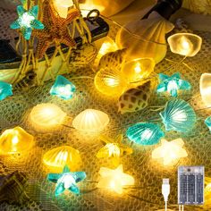 some lights that are on a table with shells and starfishs around them,