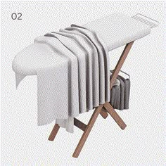 an ironing board with several folded cloths on it and two folding chairs next to it