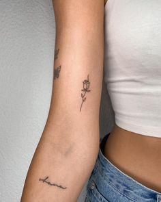 a woman's arm with a rose tattoo on the left side of her arm