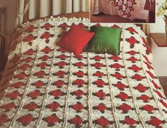 an old photo of a bed with red and green pillows