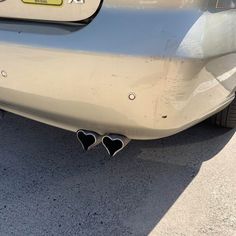 the rear end of a car with two heart shaped exhaust pipes