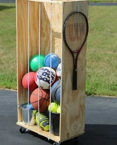 a tennis racket in a wooden box filled with balls