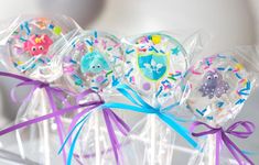 some lollipops are wrapped in cellophane and tied with purple ribbon