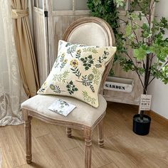 a chair with a pillow on it next to a potted plant