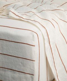 an image of a bed with white and brown stripes on it's coverlet