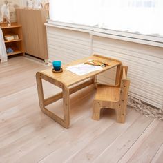 a child's wooden table and chair set up in a playroom with white walls