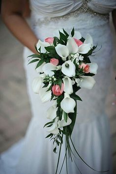 a bride holding a bouquet of white and pink flowers