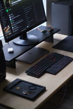 a computer monitor sitting on top of a wooden desk next to a keyboard and mouse