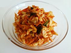 a glass bowl filled with food on top of a white table