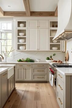 a kitchen with white cabinets and wood floors