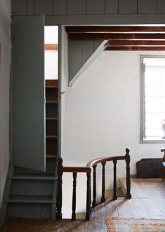 an empty room with stairs leading up to a window