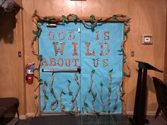 a blue door decorated with branches and words that say, god is wild about us