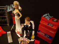 a bride and groom figurine sitting on top of a table next to magazines