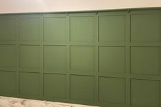 a bathroom with green painted walls and white counter top, in the process of remodeling