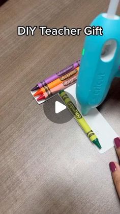 a person is holding some crayons and glue on a piece of paper with the words diy teacher gift