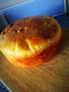 a loaf of bread sitting on top of a wooden cutting board