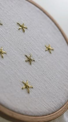 a close up of a cross stitch with gold stars on it