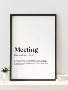 a black and white poster with the words meeting on it next to a potted plant