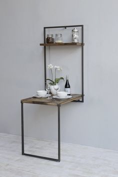 the shelf is made out of metal and has two shelves on each side, with flowers in vases