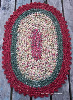 a red and green rug sitting on top of a wooden floor next to a bench