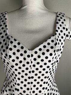 This Betsey Johnson polka dot dress is such a cutie!  It has a white background with is covered with snappy little black dots. It is a fit and flair frock with a sweet heart neckline, a back zipper and a very interesting shoulder strap design across the upper arm. To top it offit has pockets! It is in very good preowned condition. It is a size 6 but remember that Betsey's clothes tend to run small. Measurements are taken with garment laying flat.  17 1/2 underarm to underarm  15 inches across wa Summer Polka Dot Dress With Sweetheart Neckline, Polka Dot Square Neck Party Dress, Polka Dot Square Neck Dress For Parties, Fitted Polka Dot Dress With Sweetheart Neckline, Elegant Polka Dot Dress With Square Neck, Elegant Polka Dot Dress With Sweetheart Neckline, Summer Polka Dot Dresses With Fitted Bodice, Fitted Polka Dot Dress With Square Neck, Fitted Polka Dot Lined Dresses