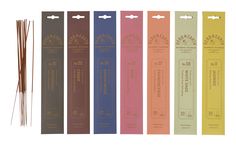 six incense sticks lined up in different colors and sizes, each with an individual's name