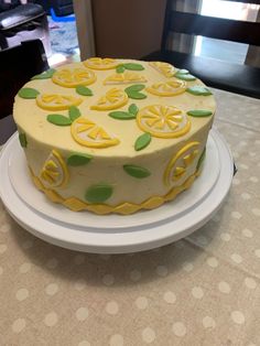 a white plate topped with a cake covered in yellow and green icing on top of a table