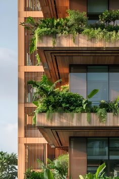 an apartment building with plants growing on the balconies